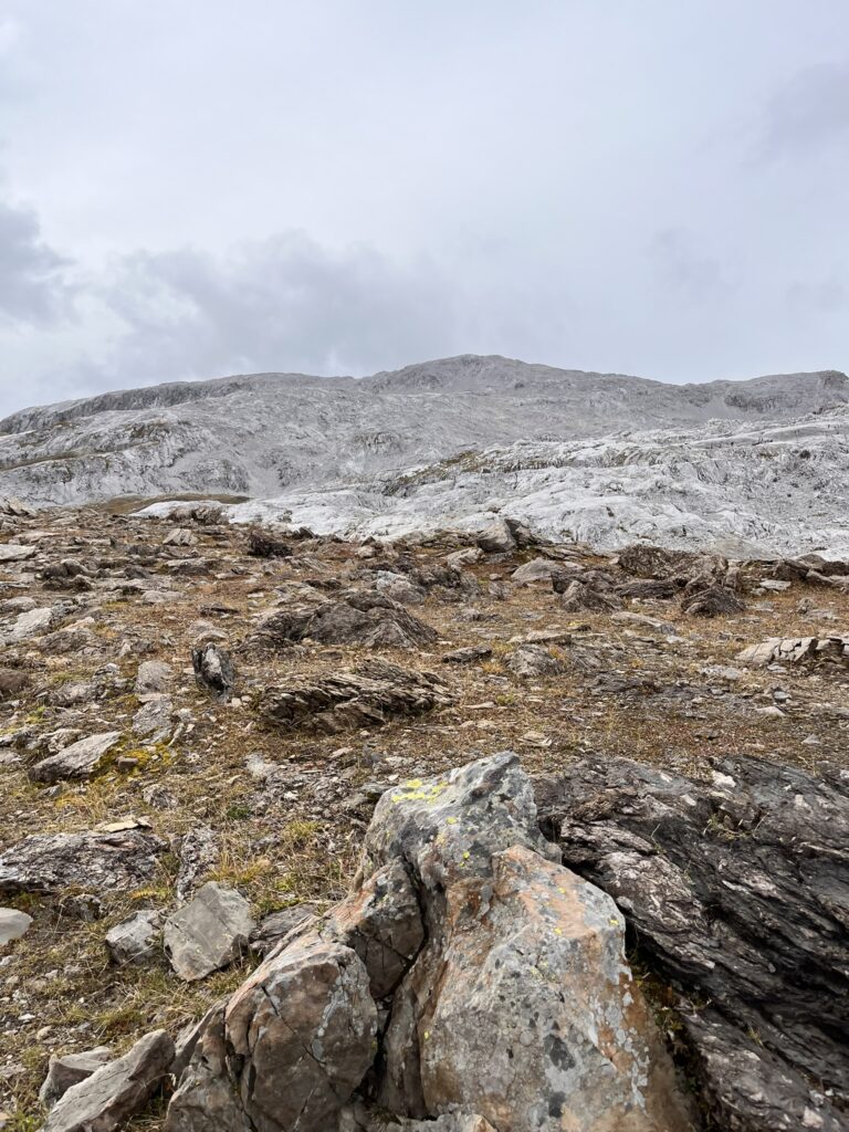 Karge Berglandschaft mit Felsen und grauem Himmel. Transalpine Run 2025. - We Run 4 Fun!