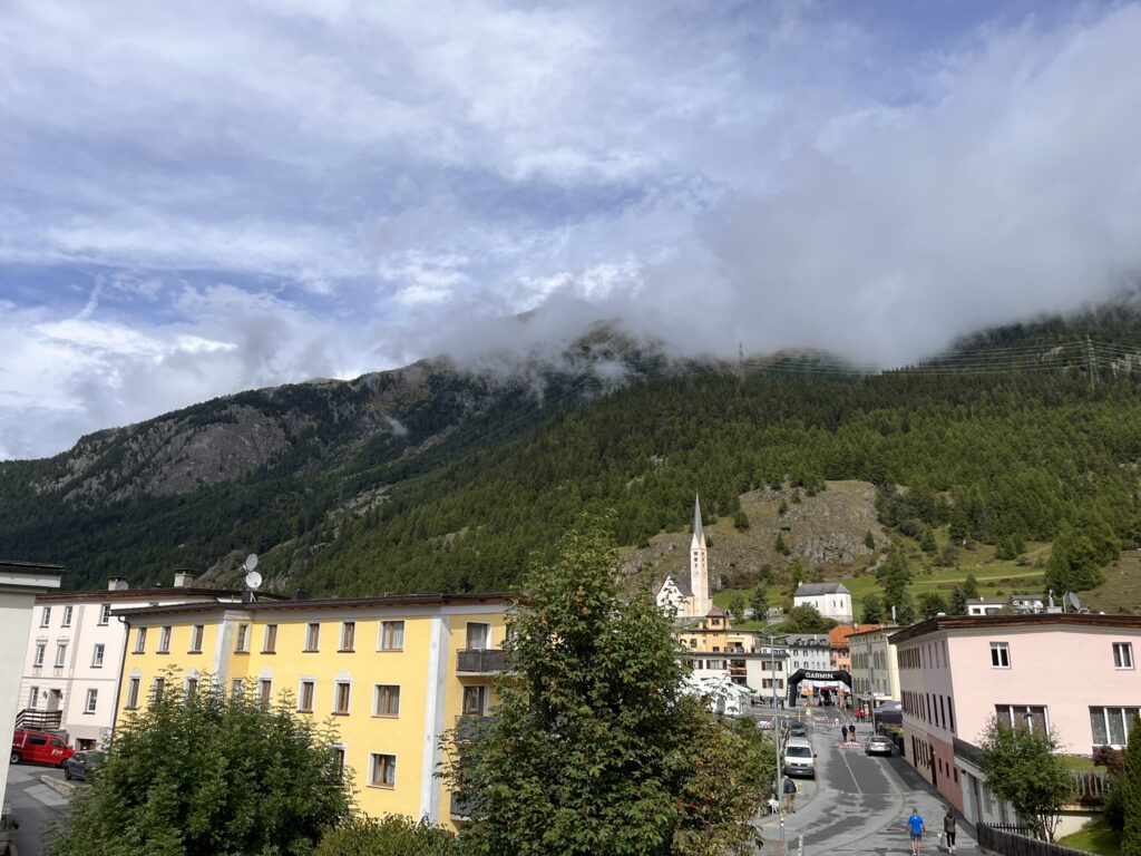Berglandschaft in den Alpen mit Dorf und Kirche, Transalpine Run 2025 - We Run 4 Fun!