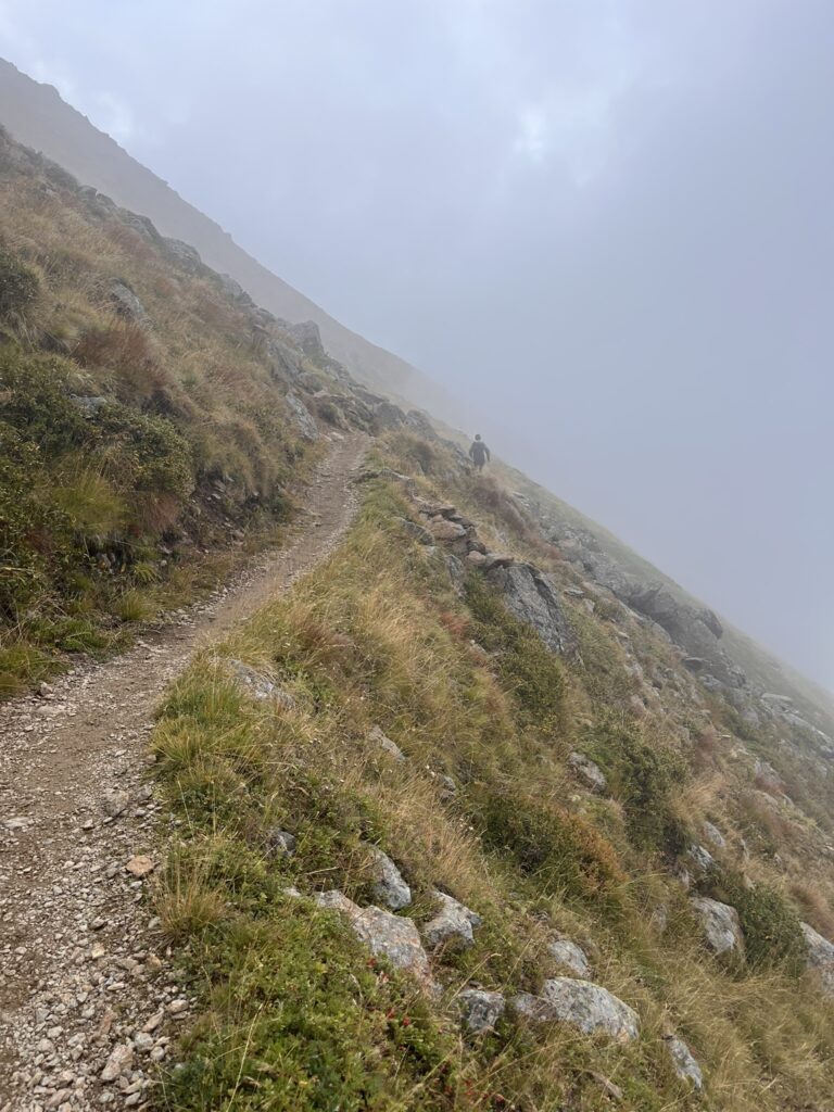 Bergpfad im Nebel, Wanderer auf dem Weg zur Transalpine Run 2025. - We Run 4 Fun!